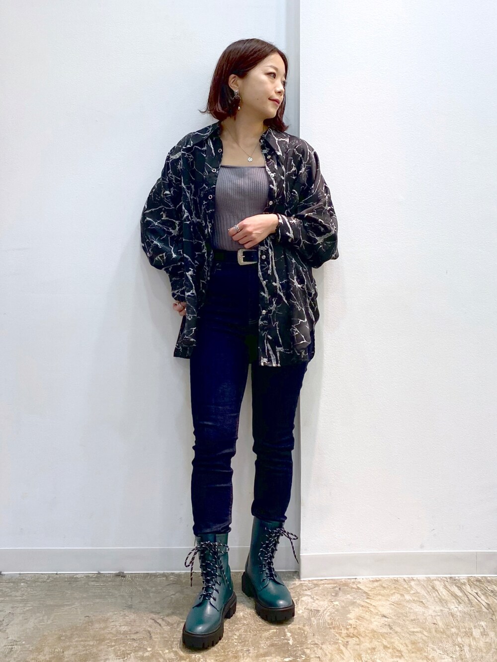 ブラック系のシャツ/ブラウス、グレー系のニット/セーター、グリーン系のブーツを着用したレディースの秋コーディネートの2枚目の写真