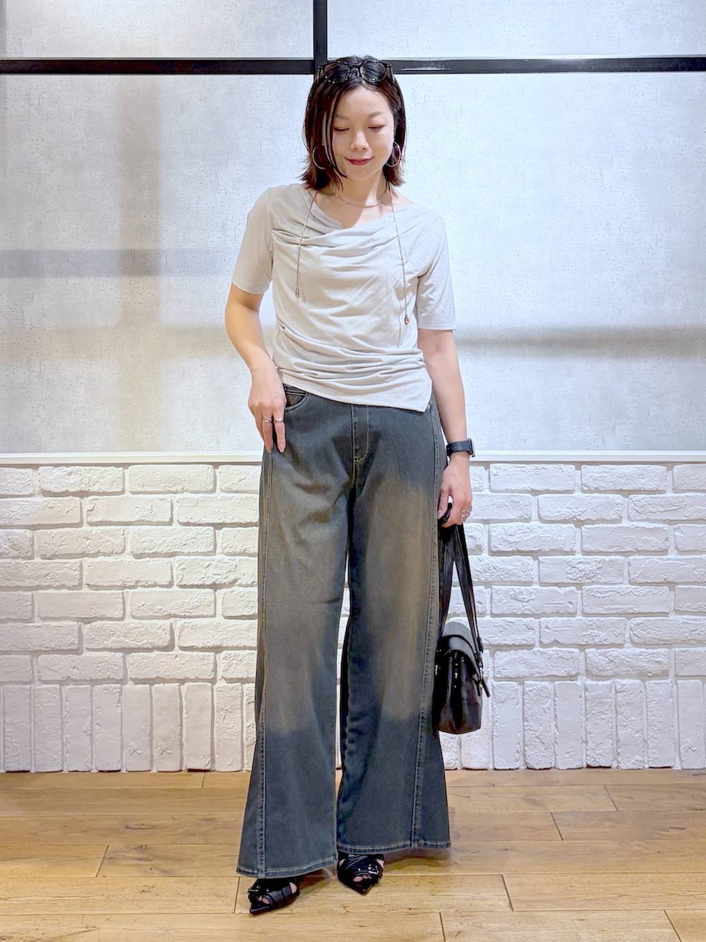 グリーン系のデニムパンツ、ブラック系のサンダル、ベージュ系のTシャツ/カットソーを着用したレディースの夏コーディネートの9枚目の写真
