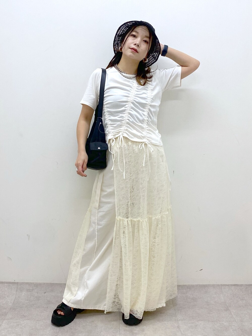 ホワイト系のTシャツ/カットソー、ブラック系のサンダル、ホワイト系のデニムパンツを着用したレディースの春コーディネートの9枚目の写真