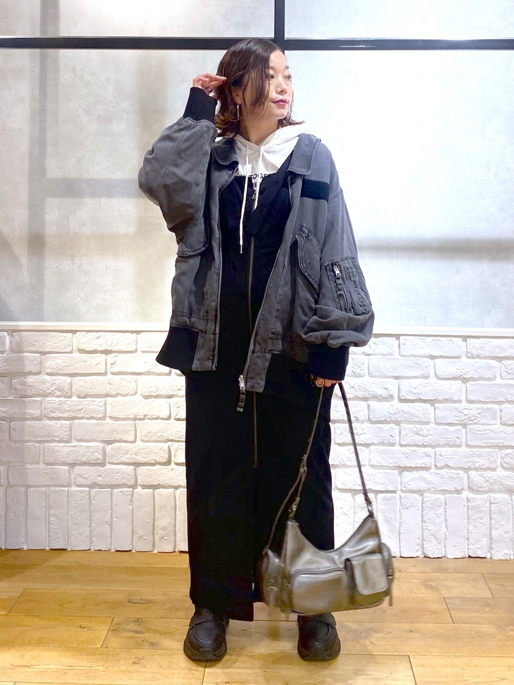 ブラック系のブルゾン、ブラック系のワンピース、ブラック系のローファーを着用したレディースの秋コーディネートの5枚目の写真