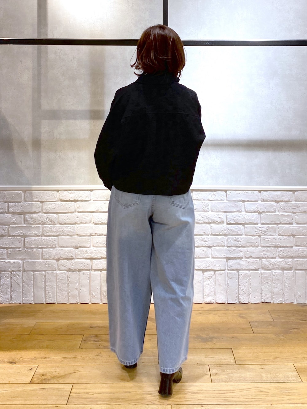 ブラック系のシャツ/ブラウス、ブルー系のデニムパンツ、ブルー系のショルダーバッグを着用したレディースの冬コーディネートの6枚目の写真