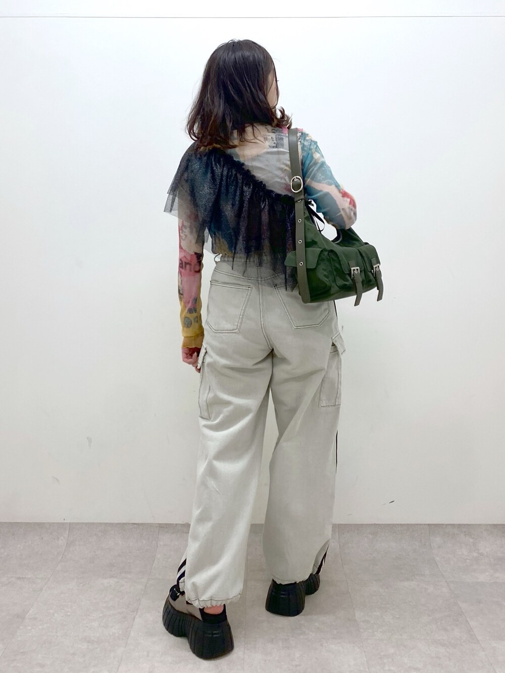 グリーン系のショルダーバッグ、その他のスニーカー、ホワイト系のデニムパンツを着用したレディースの春コーディネートの5枚目の写真