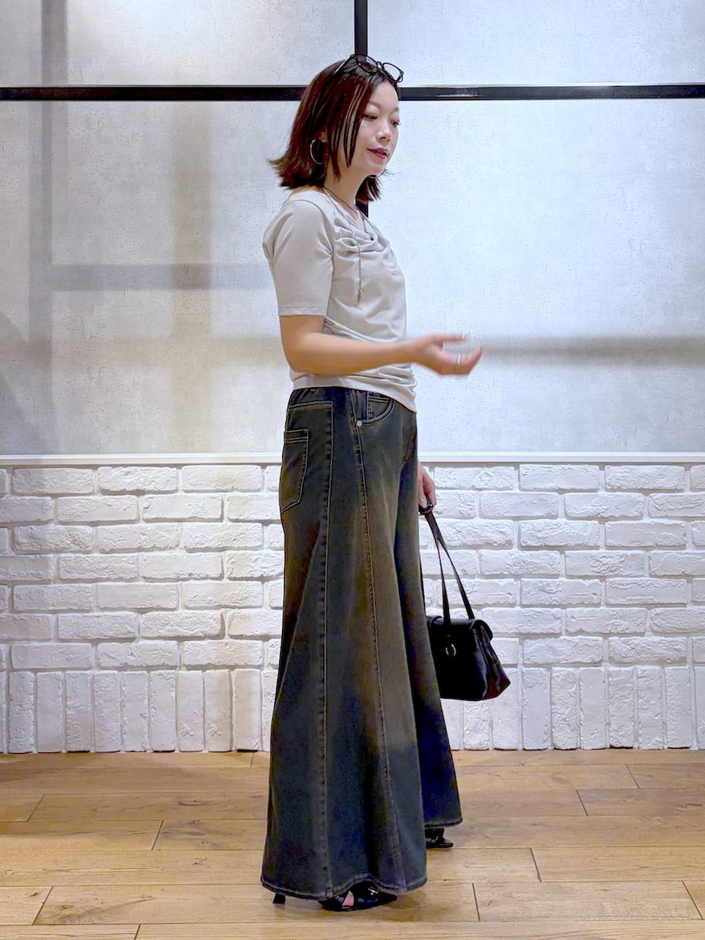 グリーン系のデニムパンツ、ブラック系のサンダル、ベージュ系のTシャツ/カットソーを着用したレディースの夏コーディネートの5枚目の写真