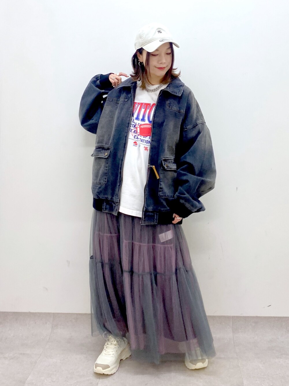 ホワイト系のTシャツ/カットソー、ブラック系のデニムジャケット、グレー系のスカートを着用したレディースの冬コーディネートの8枚目の写真