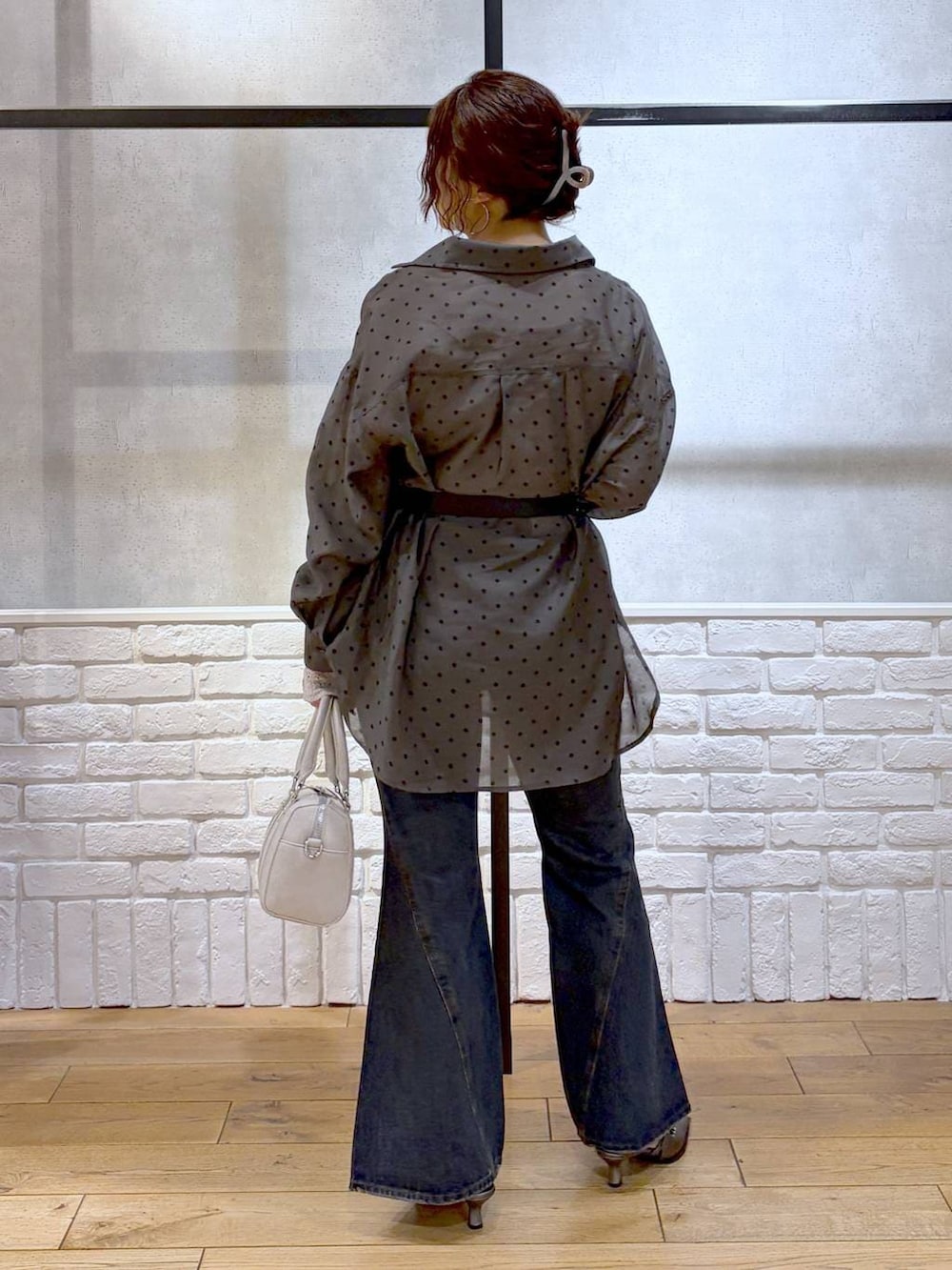 ブルー系のデニムパンツ、ホワイト系のボストンバッグ、ブラウン系のサンダルを着用したレディースの春コーディネートの4枚目の写真