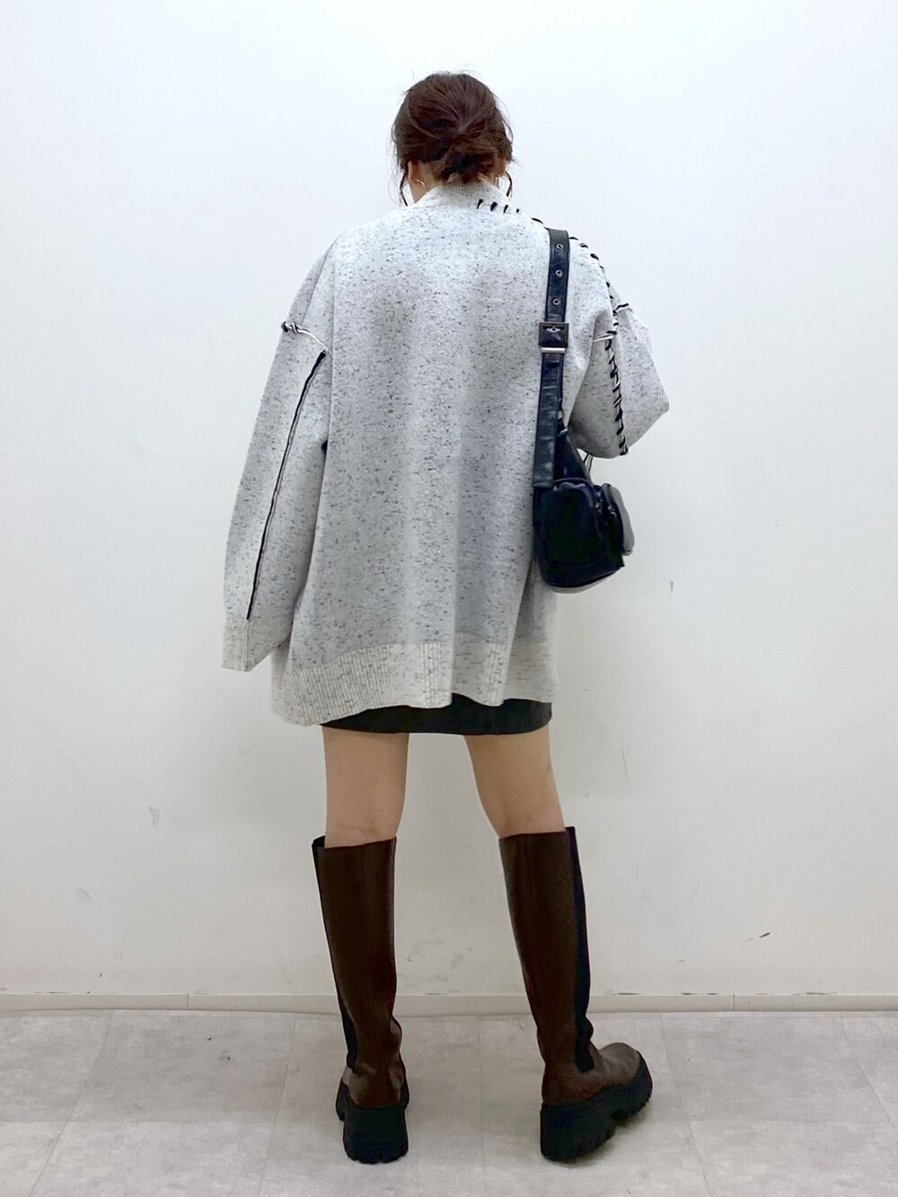 ホワイト系のニット/セーター、シルバー系のTシャツ/カットソー、ブラック系のスカートを着用したレディースの秋コーディネートの6枚目の写真