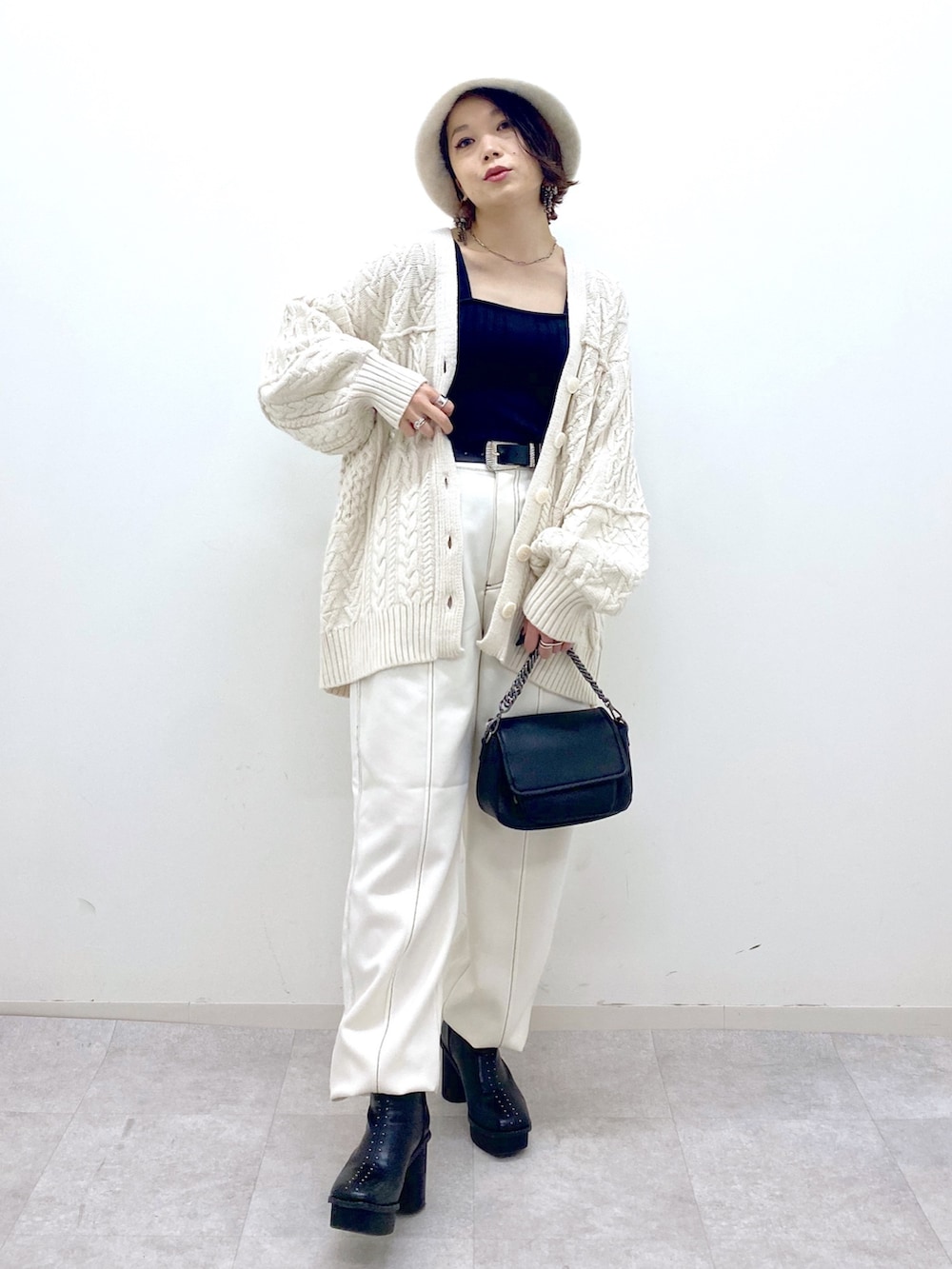 ホワイト系のその他パンツ、ブラック系のバッグ、ブラック系のブーツを着用したレディースの秋コーディネートの5枚目の写真