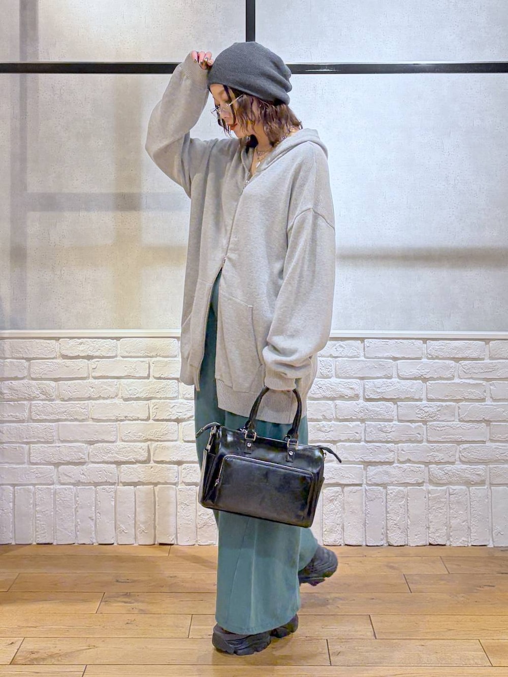 グレー系のスニーカー、グレー系のパーカー、ブラック系のショルダーバッグを着用したレディースの春コーディネートの8枚目の写真