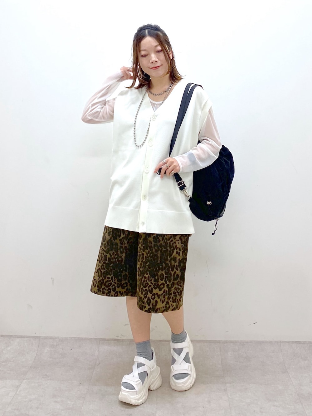 ホワイト系のカーディガン/ボレロ、ホワイト系のTシャツ/カットソー、ブラック系のバックパック/リュックを着用したレディースの春コーディネートの9枚目の写真