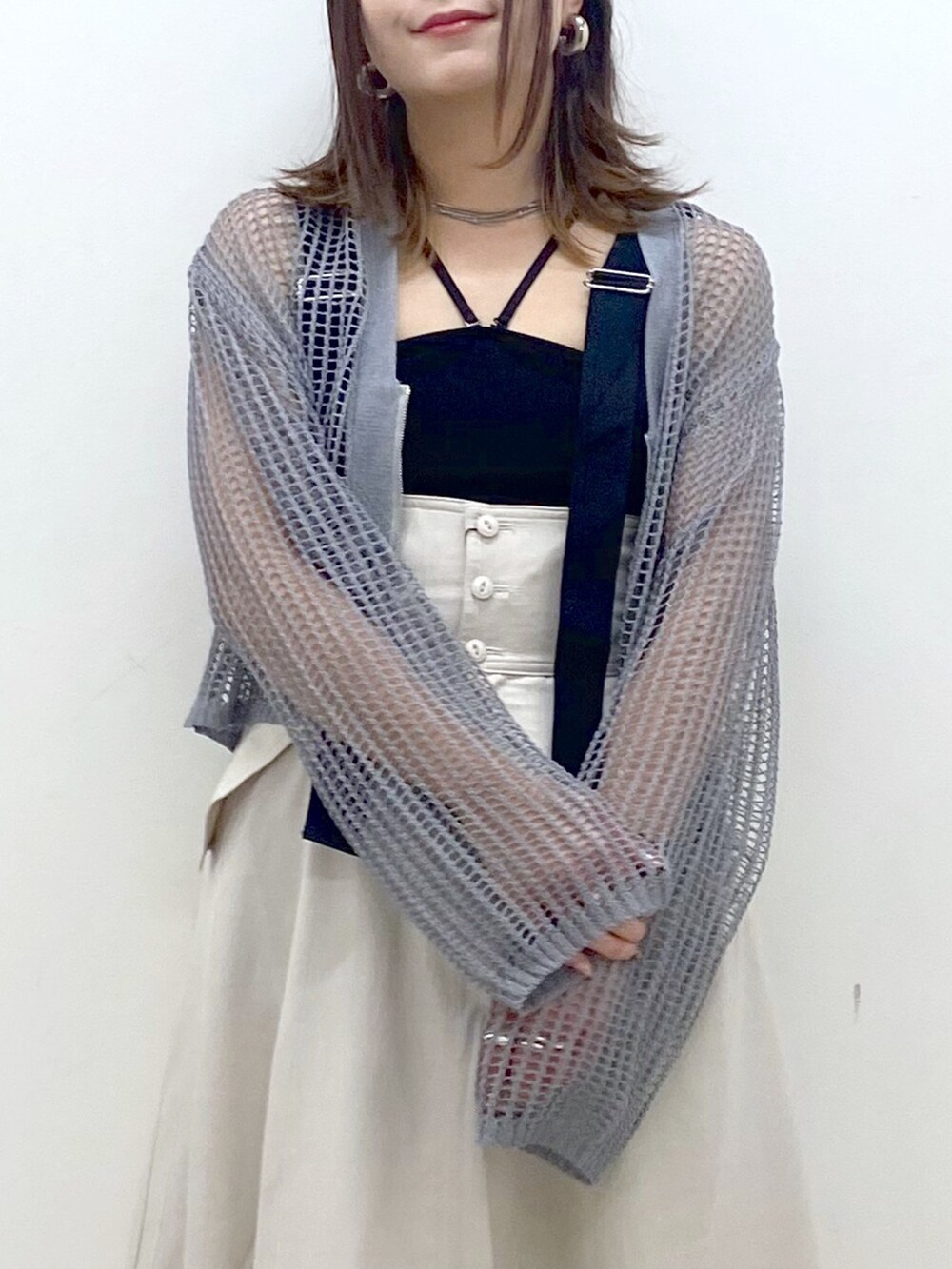 ブラック系のキャミソール、グレー系のカーディガン/ボレロ、ベージュ系のスカートを着用したレディースの春コーディネートの2枚目の写真