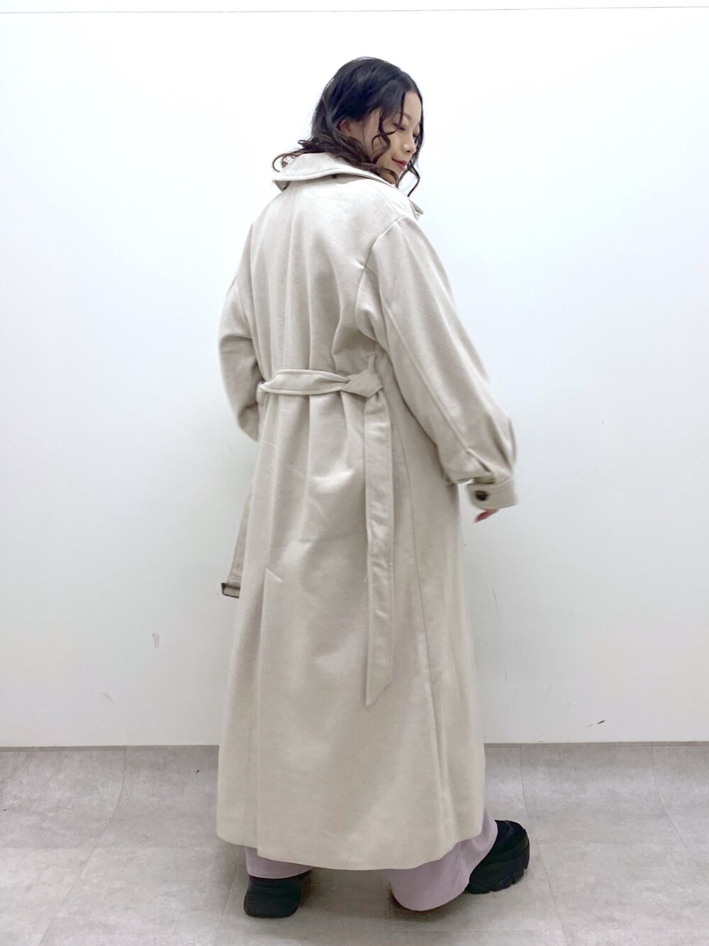 グレー系のチェスターコート、ホワイト系のニット/セーター、ピンク系のカーゴパンツを着用したレディースの冬コーディネートの4枚目の写真