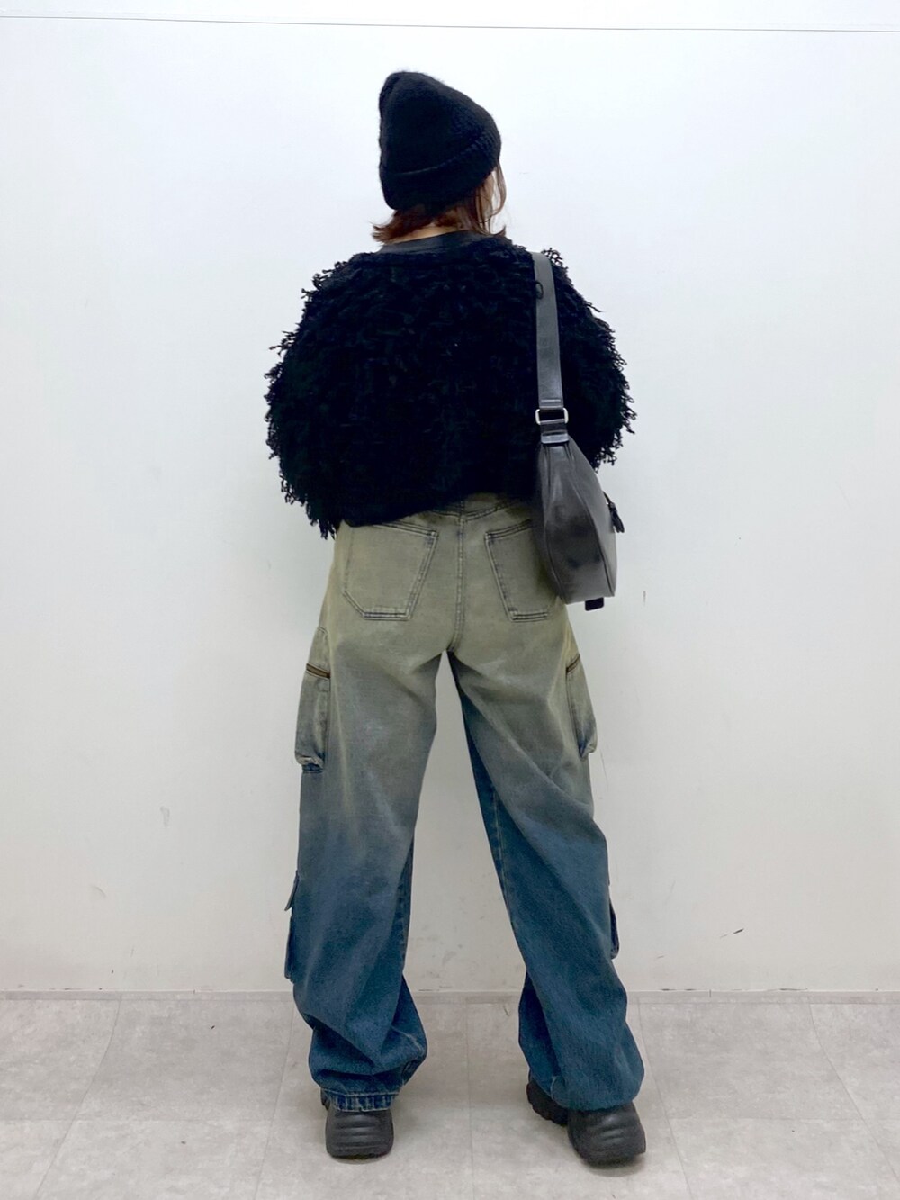 ブルー系のデニムパンツ、ブラック系のTシャツ/カットソー、ブラック系のカーディガン/ボレロを着用したレディースの秋コーディネートの7枚目の写真