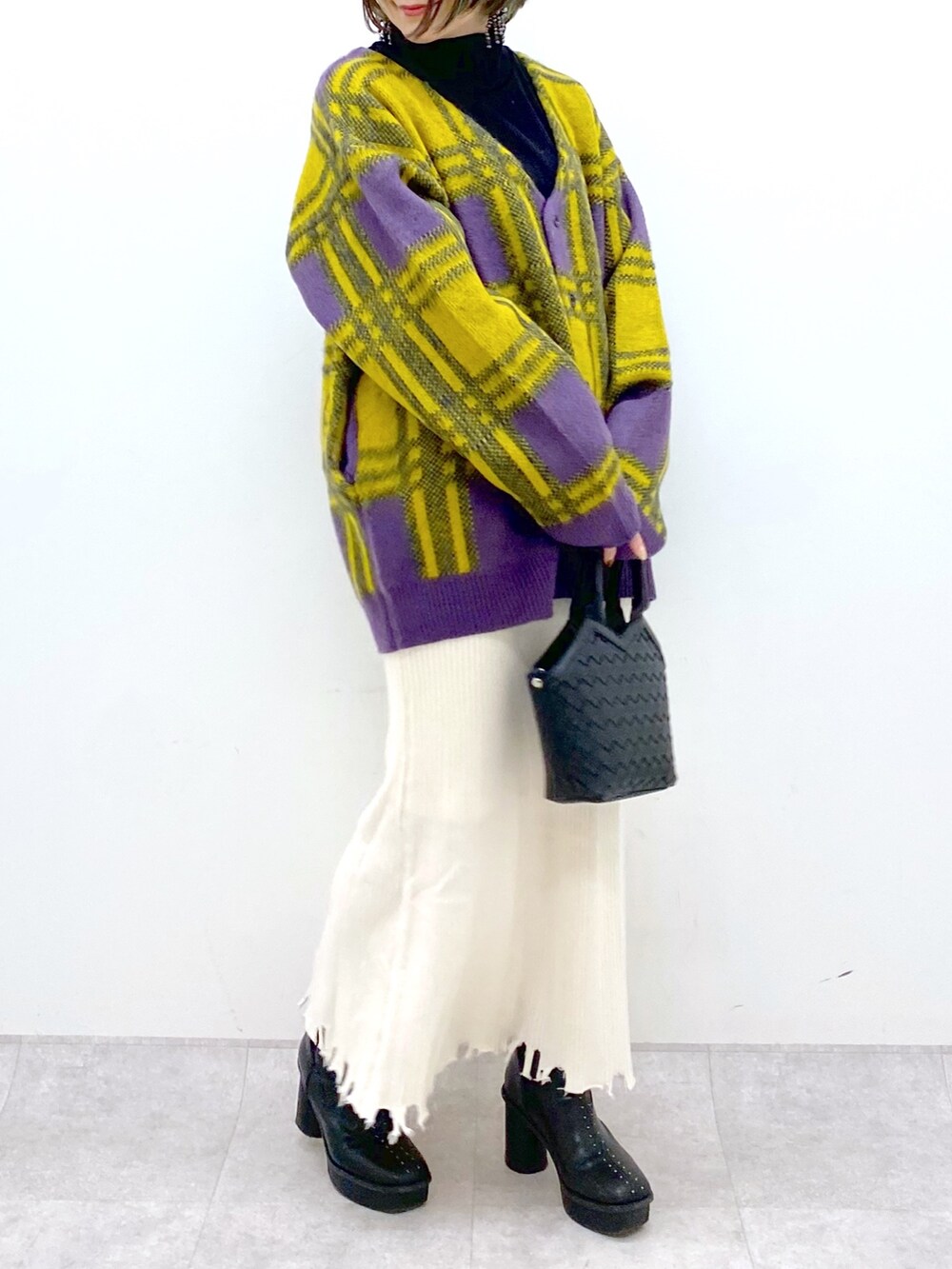 ホワイト系のトップス、ゴールド系のスカート、ブラック系のブーツを着用したレディースの冬コーディネートの5枚目の写真