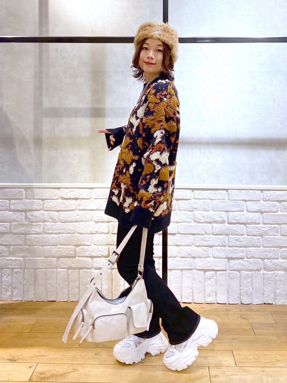 ブルー系のニット/セーター、ブルー系のデニムパンツ、ホワイト系のショルダーバッグを着用したレディースの冬コーディネートの7枚目の写真