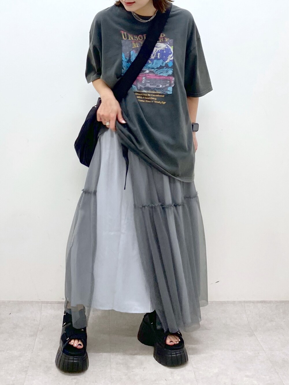 グレー系のTシャツ/カットソー、グレー系のスカート、ブラック系のスニーカーを着用したレディースの夏コーディネートの2枚目の写真