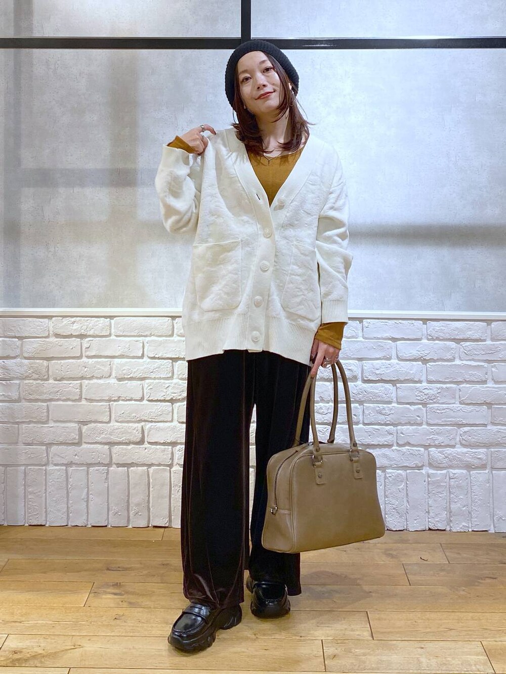 ベージュ系のボストンバッグ、イエロー系のTシャツ/カットソー、ブラック系のローファーを着用したレディースの冬コーディネートの9枚目の写真