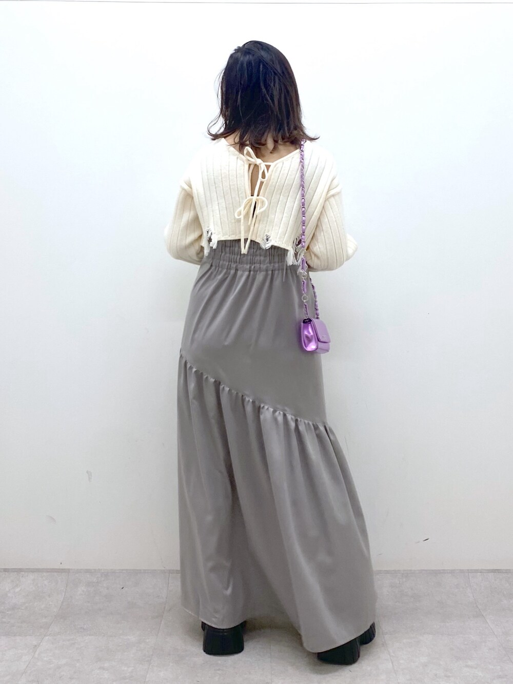 ホワイト系のワンピース、ピンク系のショルダーバッグ、ホワイト系のブーツを着用したレディースの冬コーディネートの3枚目の写真