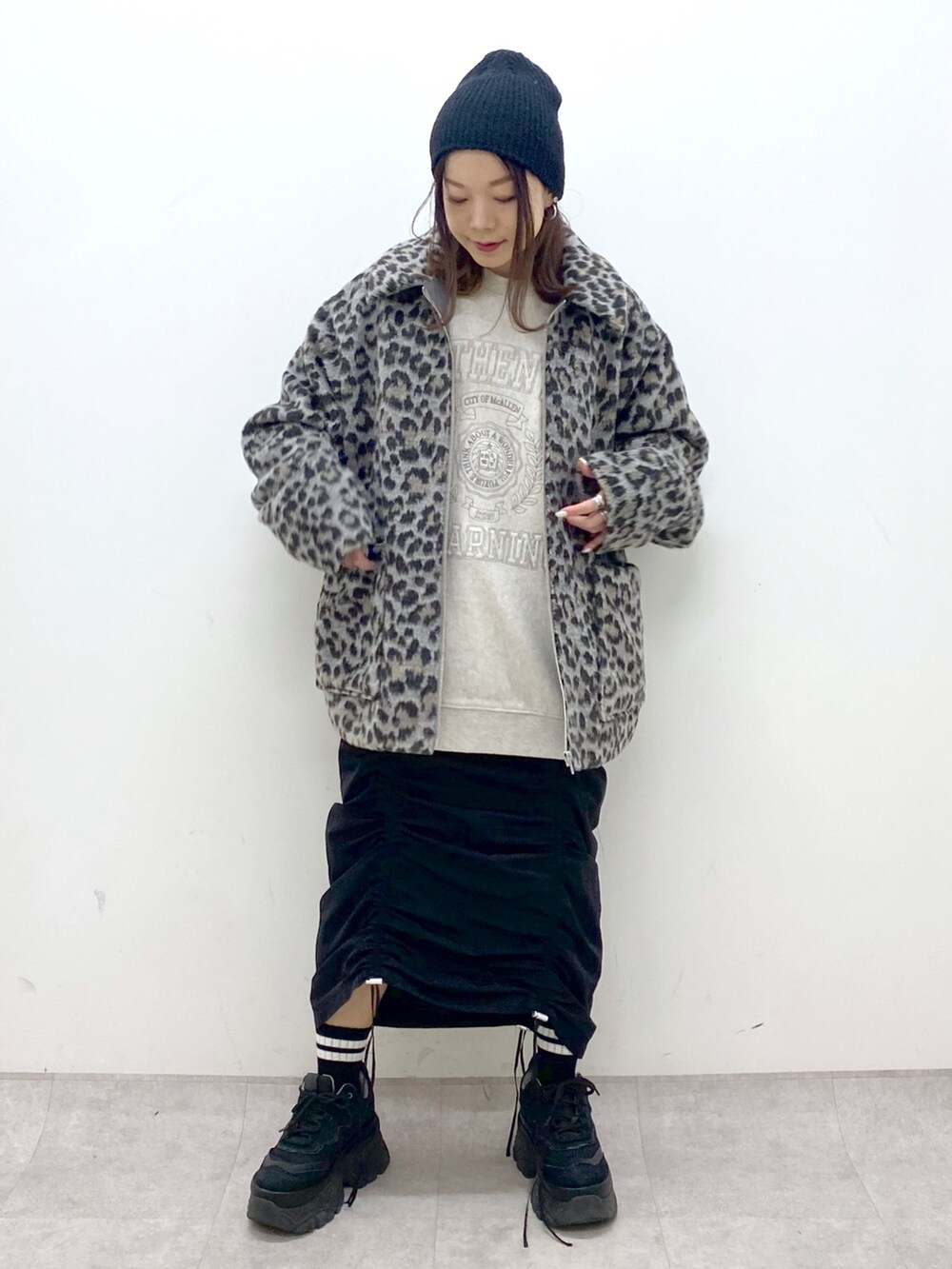 ベージュ系のスウェット、ブラック系のワンピース、ブラック系のスニーカーを着用したレディースの冬コーディネートの9枚目の写真