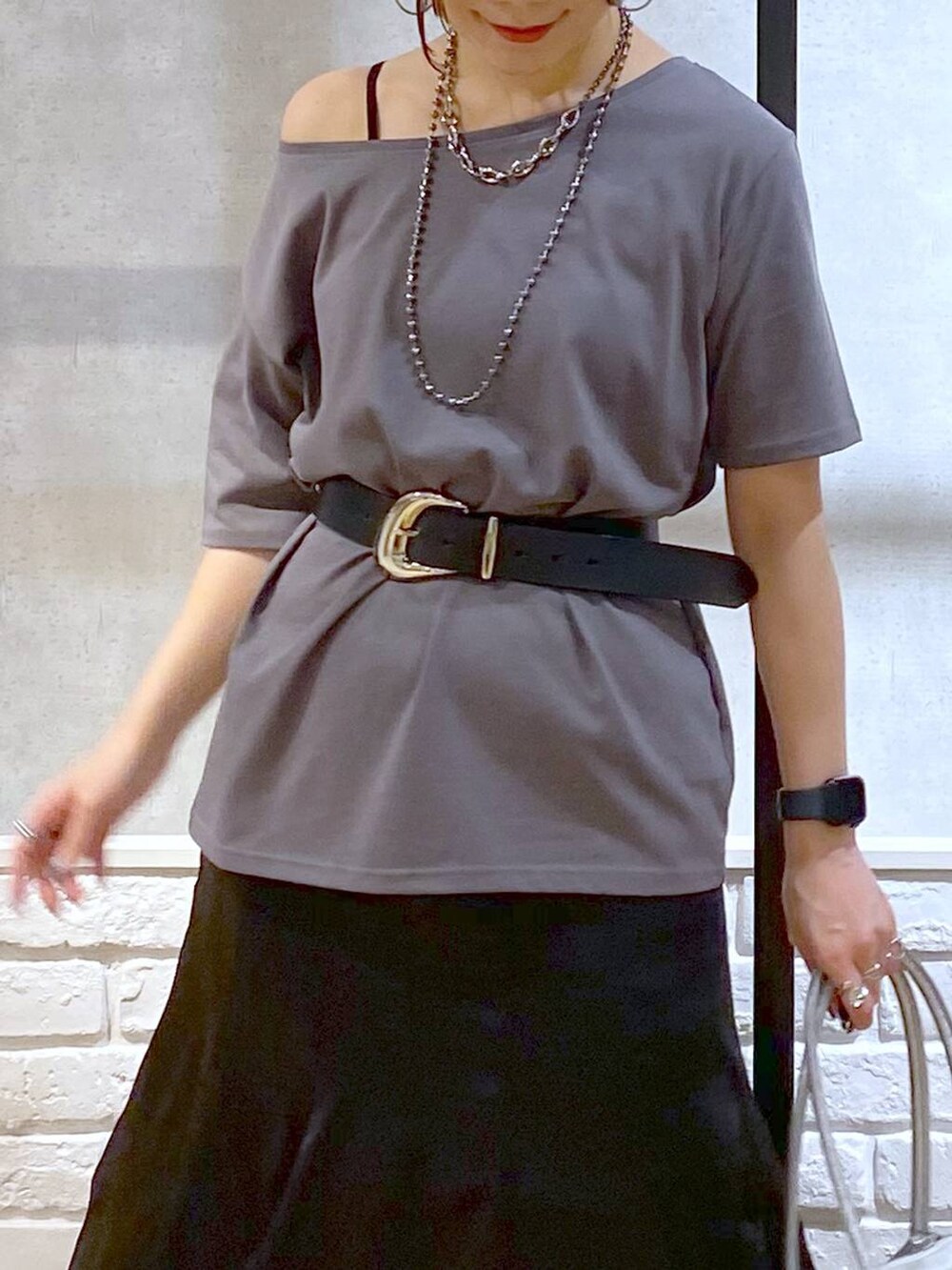 ブラック系のブーツ、シルバー系のショルダーバッグ、グレー系のTシャツ/カットソーを着用したレディースの夏コーディネートの2枚目の写真