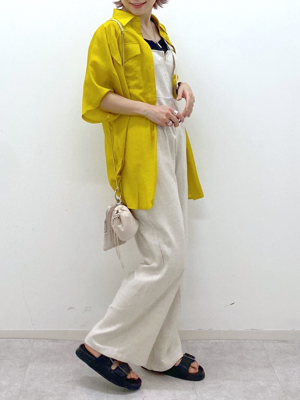 イエロー系のシャツ/ブラウス、ブラック系のサンダル、ブラック系のタンクトップを着用したレディースの夏コーディネートの5枚目の写真