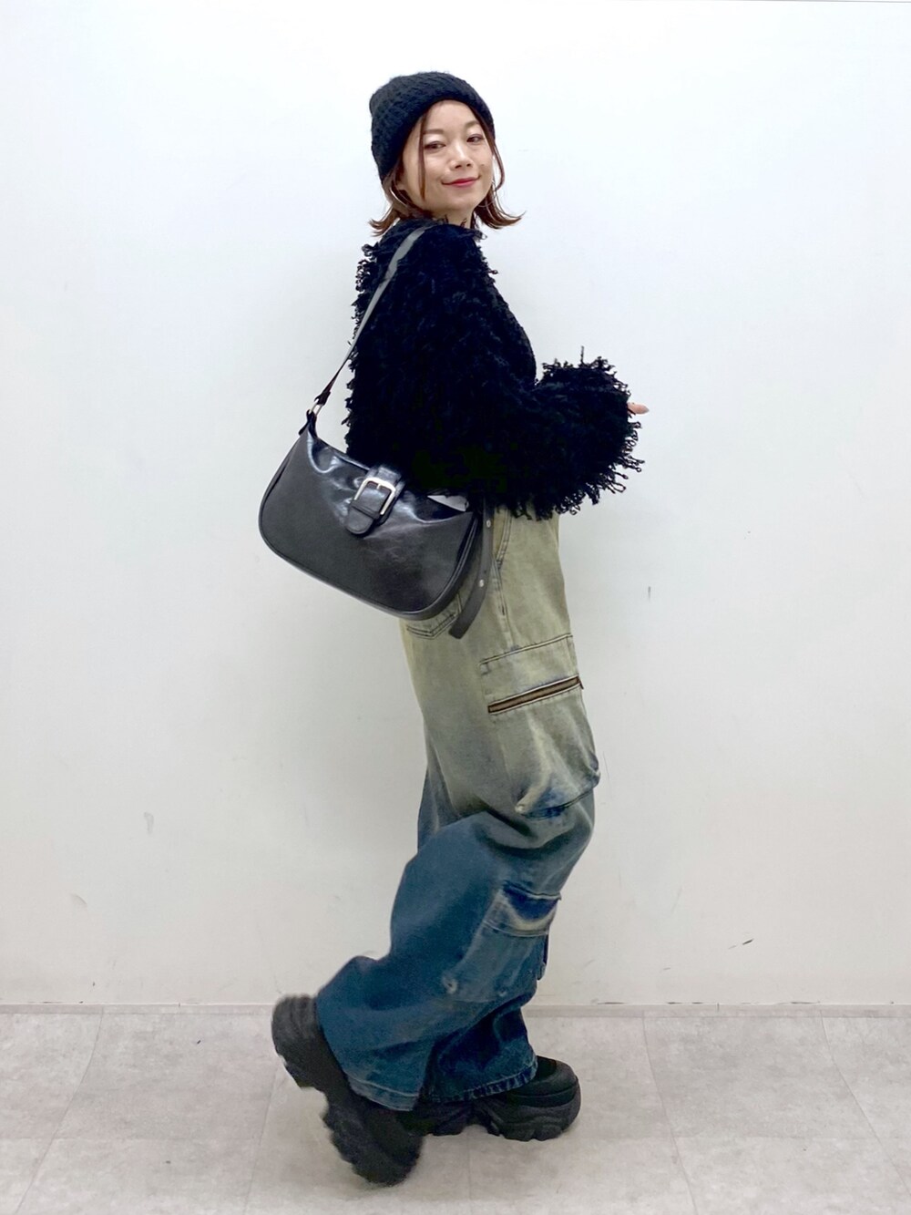 ブルー系のデニムパンツ、ブラック系のTシャツ/カットソー、ブラック系のカーディガン/ボレロを着用したレディースの秋コーディネートの6枚目の写真