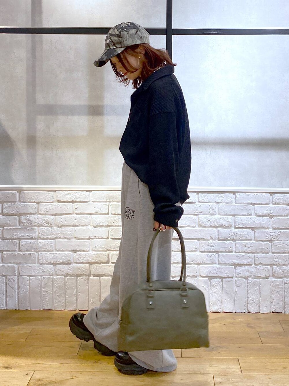 ブラック系のスニーカー、グリーン系のボストンバッグ、グレー系のスウェットパンツを着用したレディースの秋コーディネートの7枚目の写真