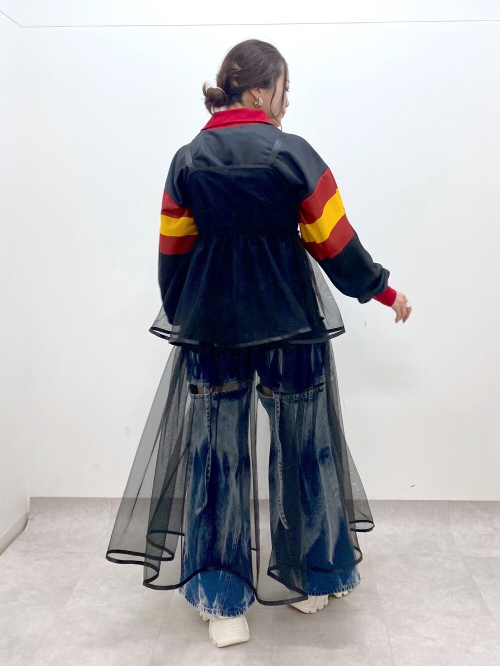 ブラック系のシャツ/ブラウス、ブラック系のワンピース、ブルー系のデニムパンツを着用したレディースの春コーディネートの6枚目の写真