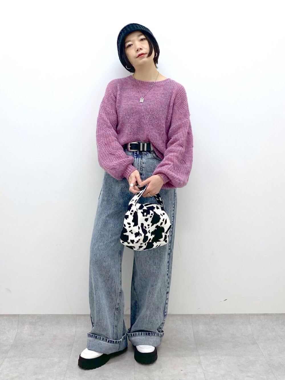 ブラック系のバッグ、ブルー系のデニムパンツ、ホワイト系のシューズを着用したレディースの冬コーディネートの5枚目の写真