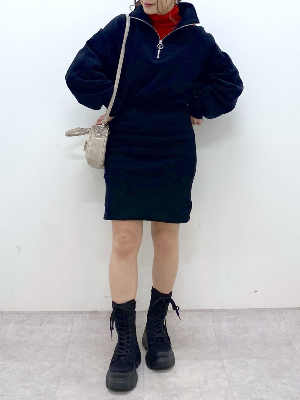 ブラック系のワンピース、レッド系のニット/セーター、ベージュ系のボストンバッグを着用したレディースの冬コーディネートの6枚目の写真