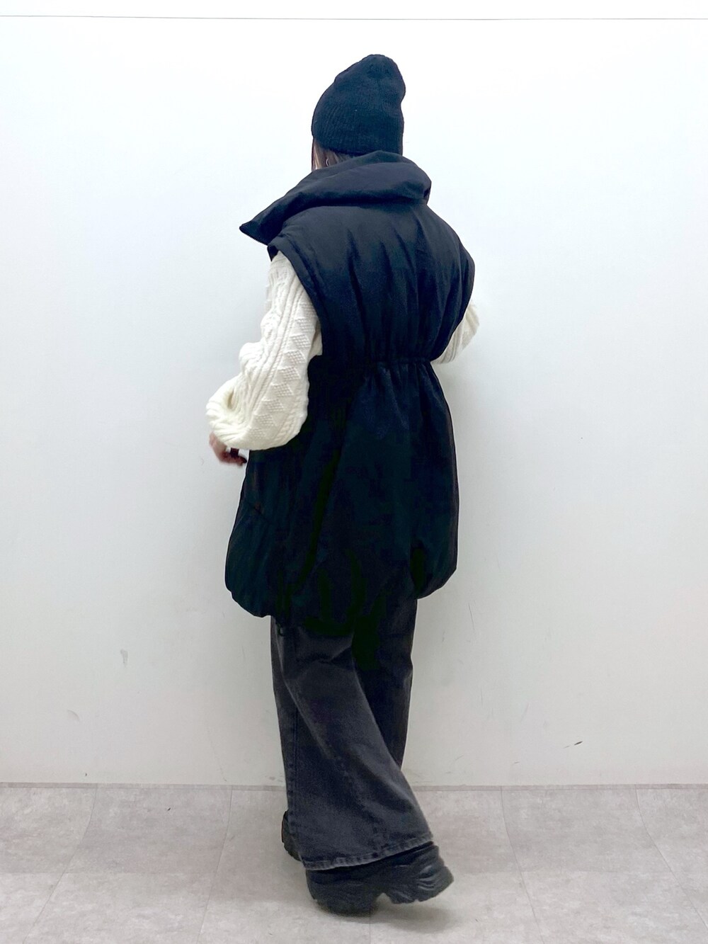 ブラック系のブルゾン、ホワイト系のニット/セーター、ブラック系のデニムパンツを着用したレディースの冬コーディネートの5枚目の写真