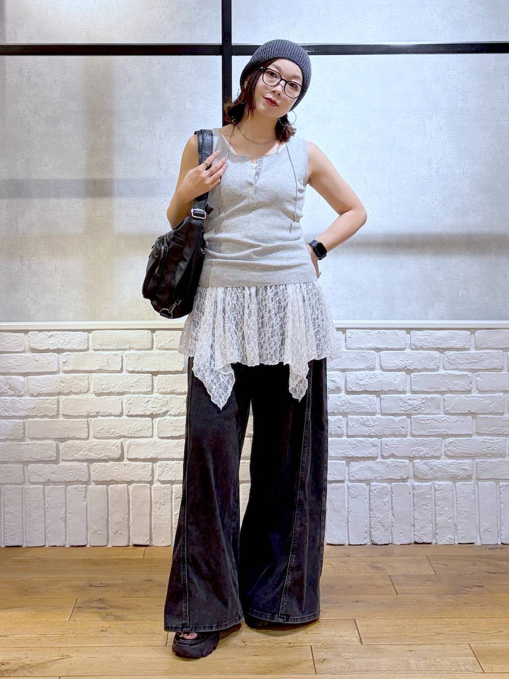 ブラック系のデニムパンツ、ブラック系のショルダーバッグ、ブラック系のサンダルを着用したレディースの夏コーディネートの4枚目の写真