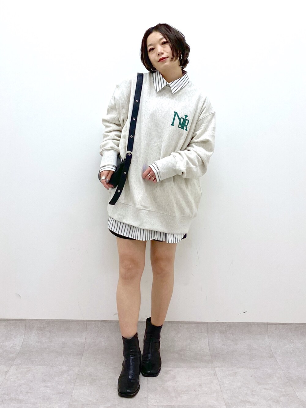 ブラック系のショルダーバッグ、ブラック系のシューズ、ベージュ系のトップスを着用したレディースの冬コーディネートの2枚目の写真