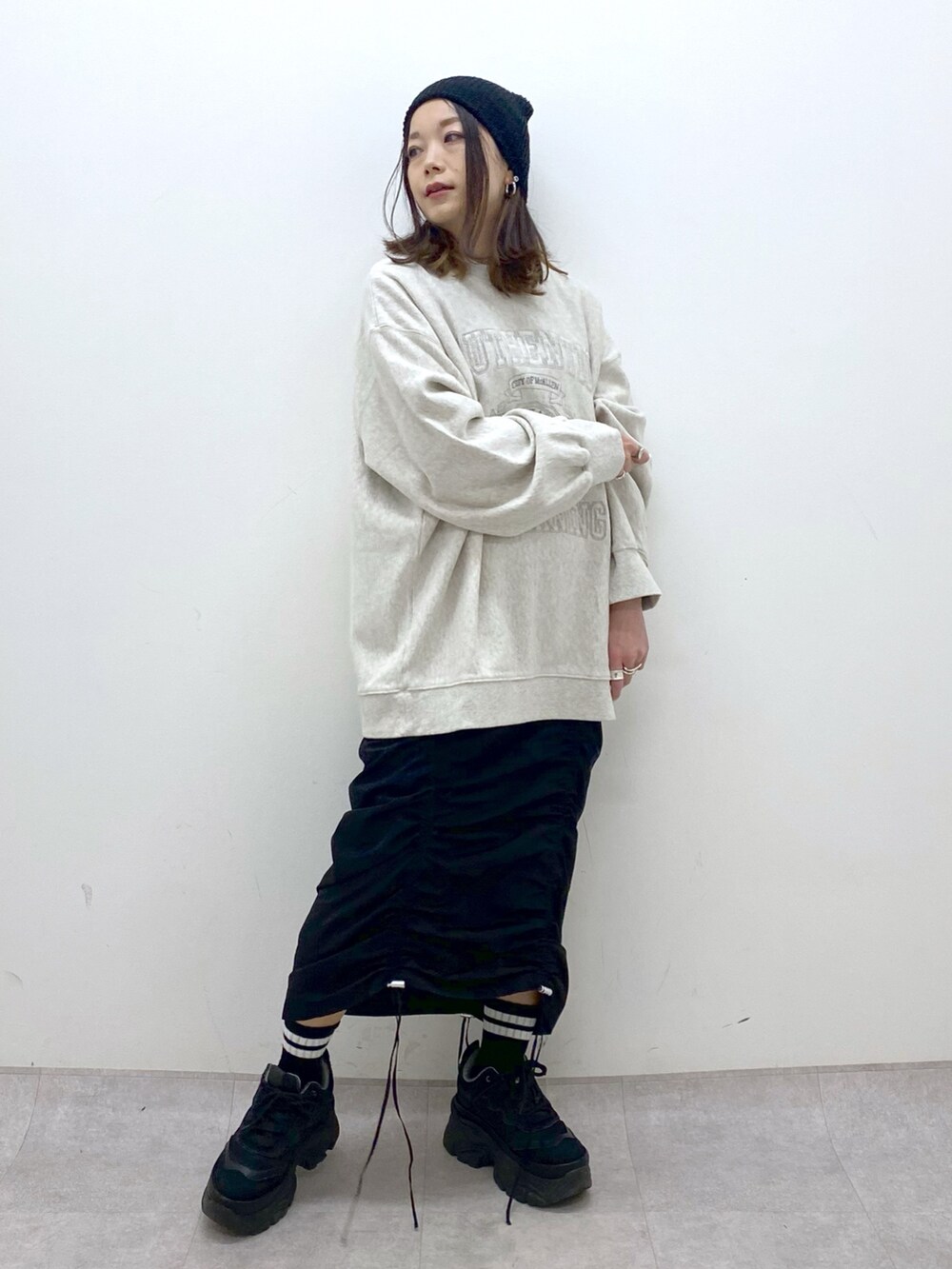 ベージュ系のスウェット、ブラック系のワンピース、ブラック系のスニーカーを着用したレディースの冬コーディネートの8枚目の写真