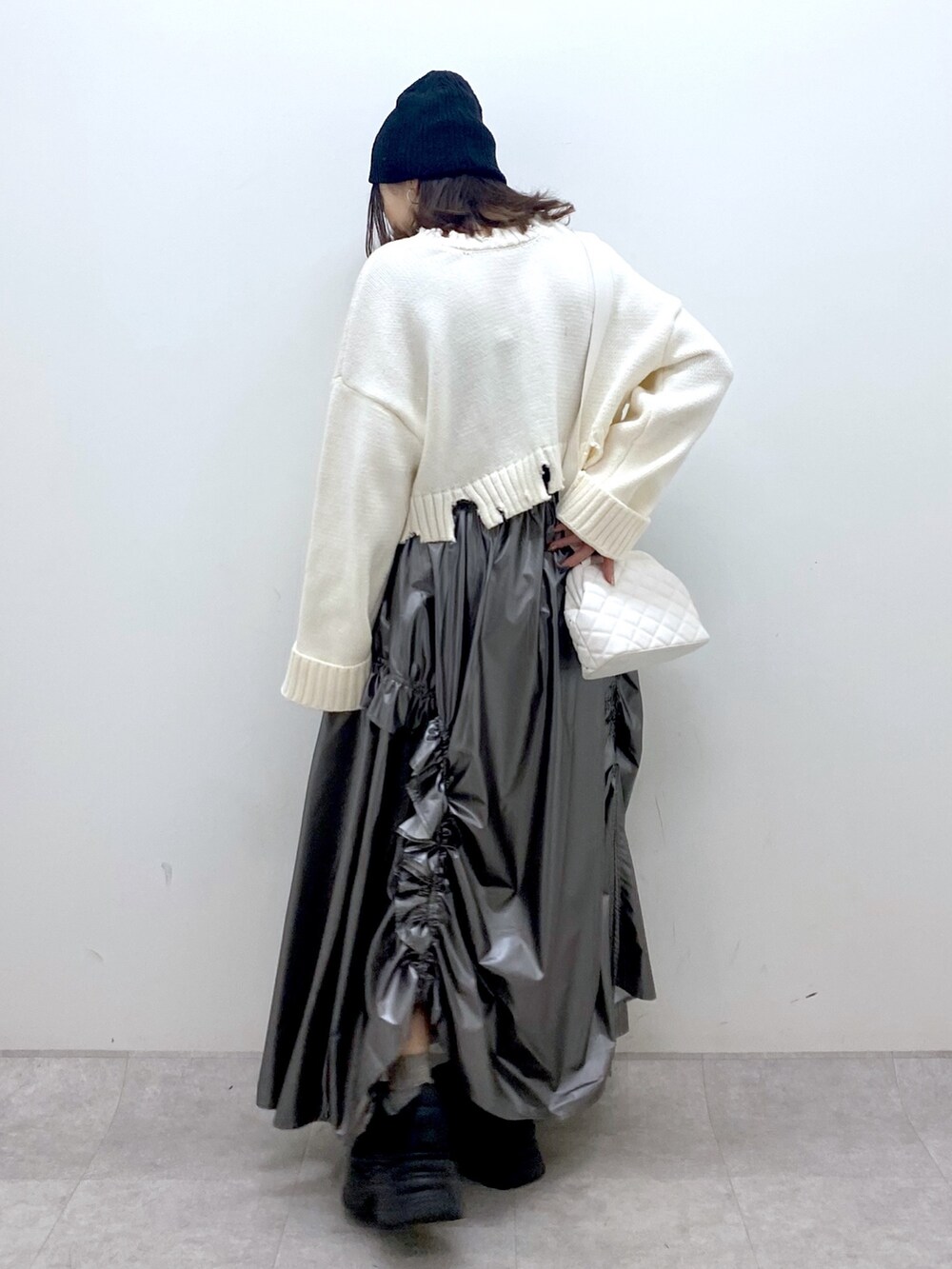 ホワイト系のニット/セーター、シルバー系のスカート、ホワイト系のショルダーバッグを着用したレディースの冬コーディネートの4枚目の写真