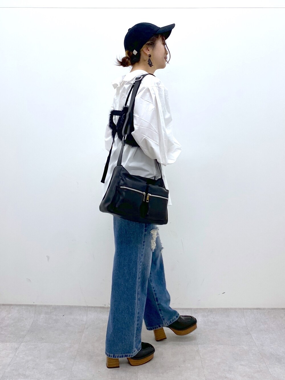 ブルー系のデニムパンツ、ホワイト系のシャツ/ブラウス、ブラック系のベストを着用したレディースの秋コーディネートの4枚目の写真