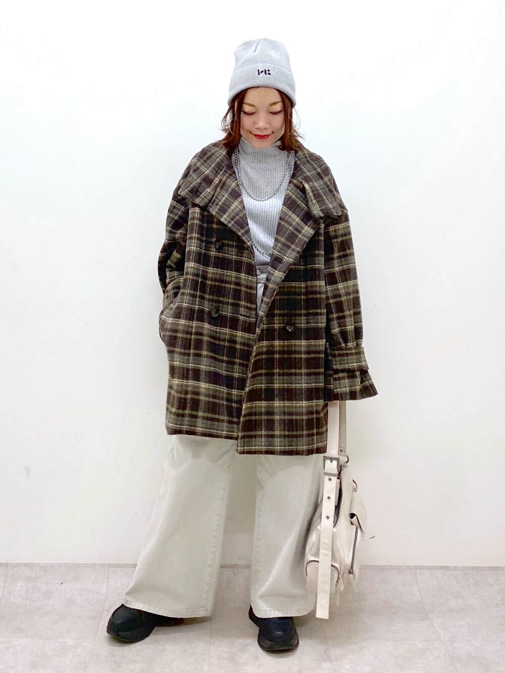 ブラウン系のテーラードジャケット、グレー系のデニムパンツ、ホワイト系のショルダーバッグを着用したレディースの冬コーディネートの8枚目の写真