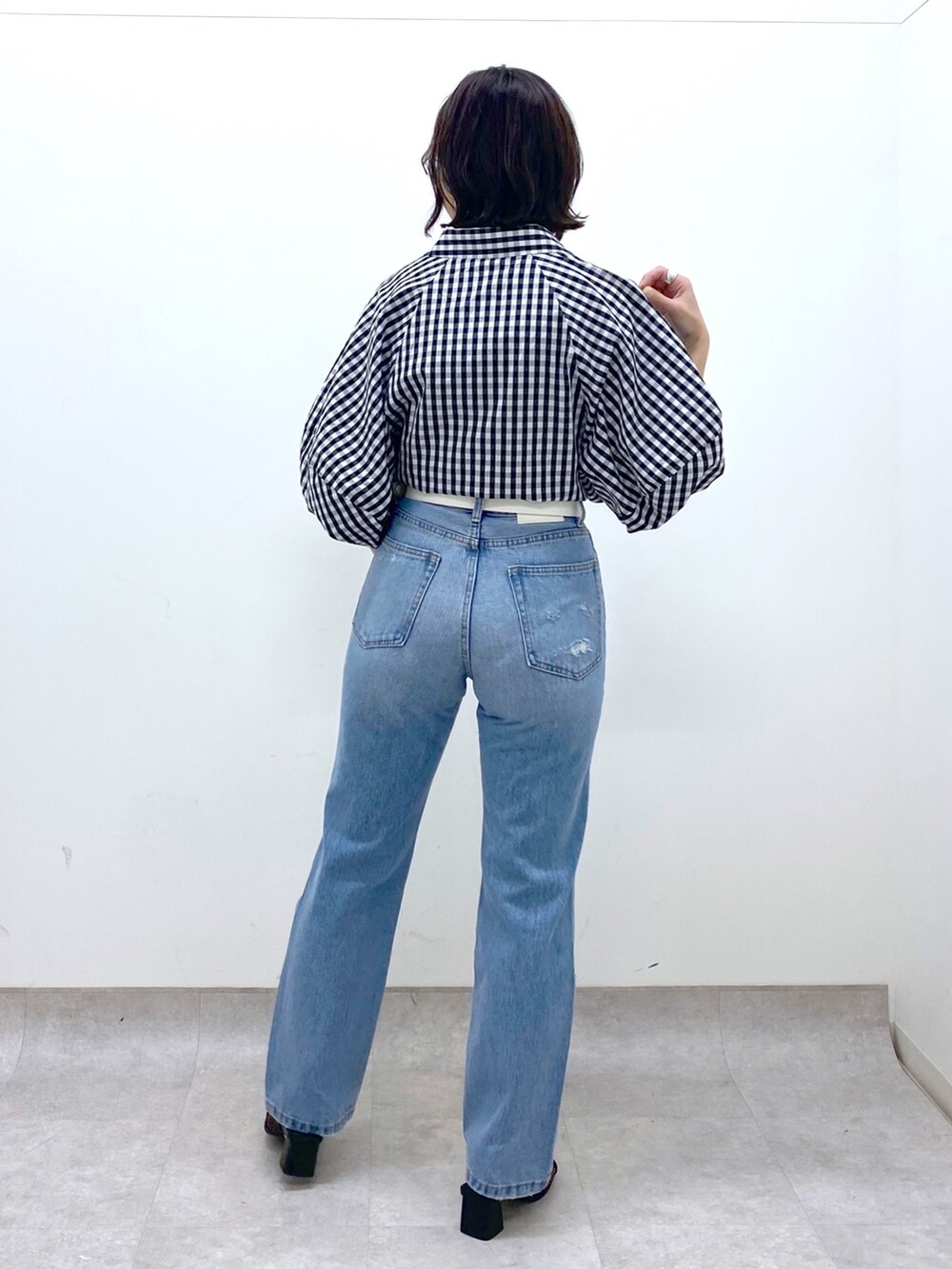 ブルー系のパンツ、ブラック系のシューズ、グリーン系のトップスを着用したレディースの春コーディネートの4枚目の写真