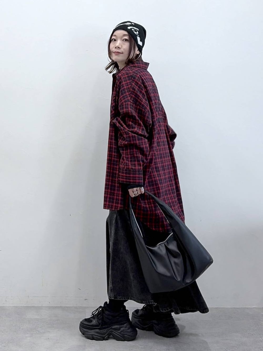 ブラック系のスニーカー、ブラック系のデニムスカート、ブラック系のトートバッグを着用したレディースの春コーディネートの6枚目の写真