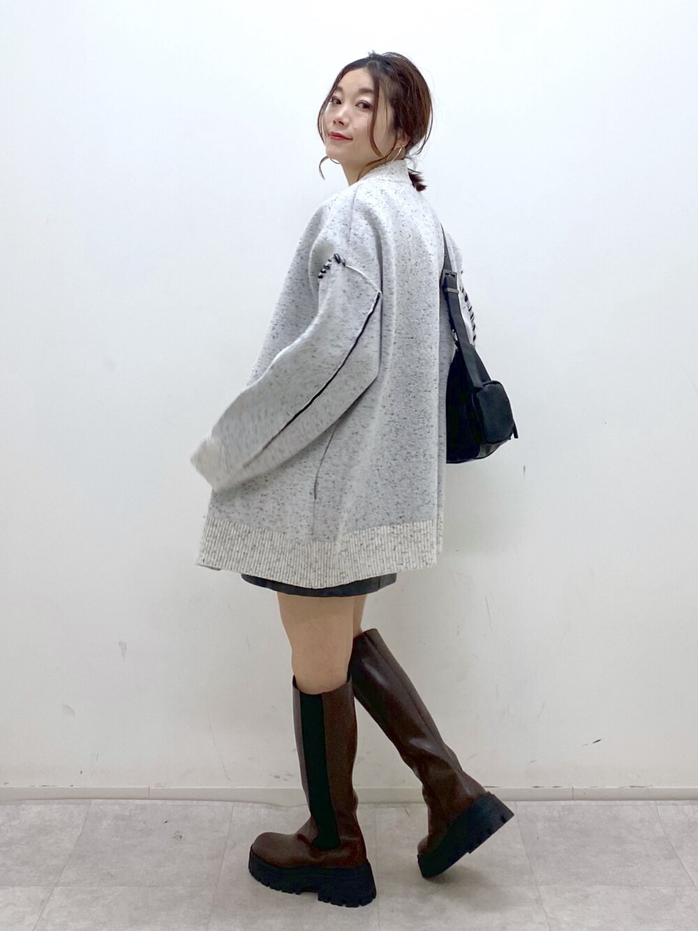 ホワイト系のニット/セーター、シルバー系のTシャツ/カットソー、ブラック系のスカートを着用したレディースの秋コーディネートの7枚目の写真