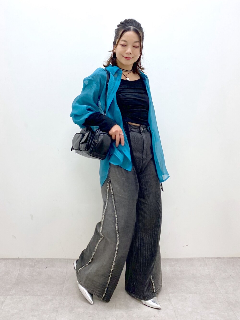 シルバー系のパンプス、ブラック系のデニムパンツ、ブラック系のショルダーバッグを着用したレディースの夏コーディネートの5枚目の写真