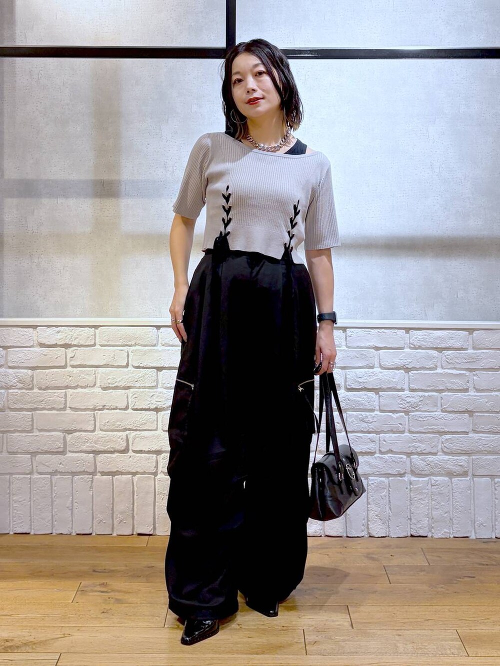 ブラック系のカーゴパンツ、グレー系のTシャツ/カットソー、ブラック系のショルダーバッグを着用したレディースの夏コーディネートの4枚目の写真