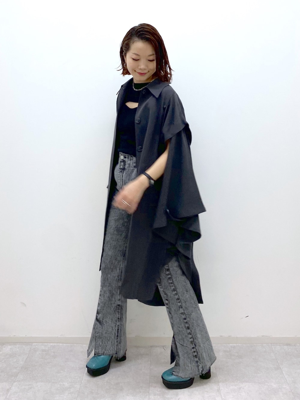 ブラック系のデニムパンツ、グレー系のポンチョ、ブラック系のトップスを着用したレディースの夏コーディネートの2枚目の写真