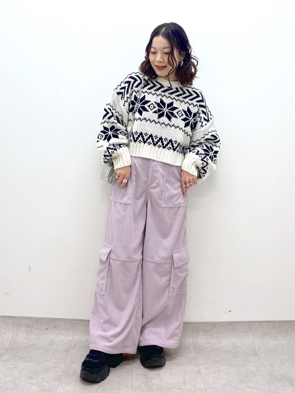 ピンク系のカーゴパンツ、ホワイト系のニット/セーター、シルバー系のショルダーバッグを着用したレディースの冬コーディネートの2枚目の写真