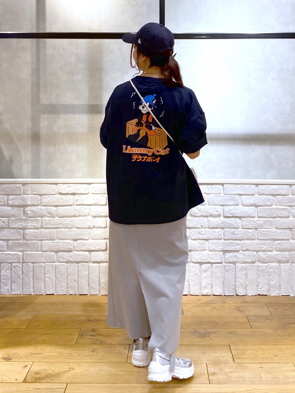 ブルー系のTシャツ/カットソー、グレー系のスカート、グレー系のスニーカーを着用したレディースの春コーディネートの6枚目の写真