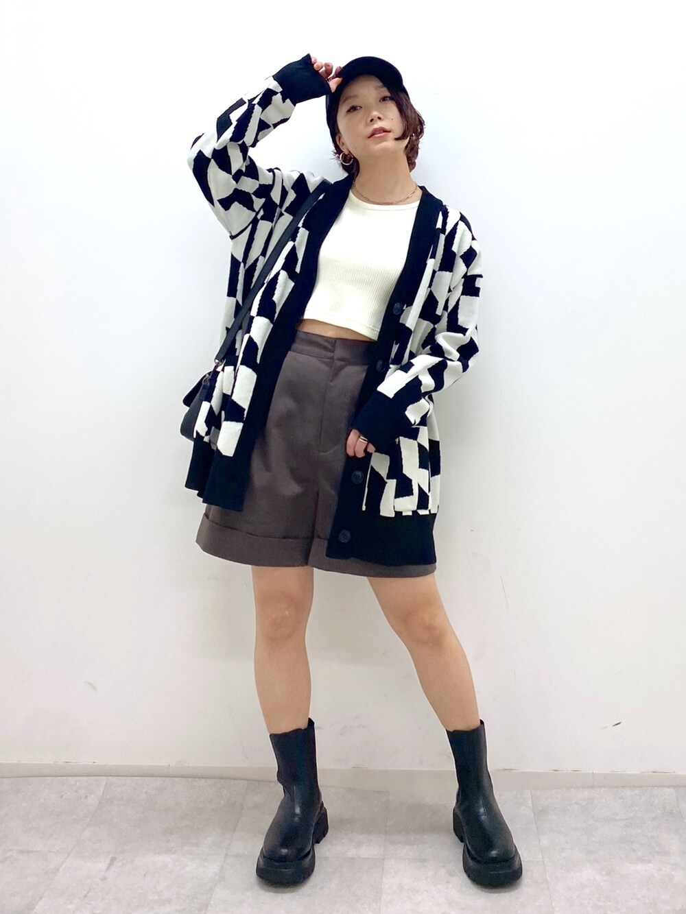 ブラック系のトップス、ブラウン系のパンツ、ホワイト系のTシャツ/カットソーを着用したレディースの秋コーディネートの4枚目の写真