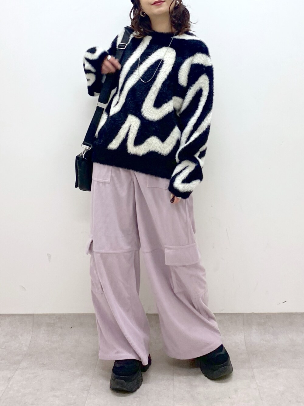 ピンク系のカーゴパンツ、ブラック系のニット/セーター、ブラック系のショルダーバッグを着用したレディースの冬コーディネートの8枚目の写真