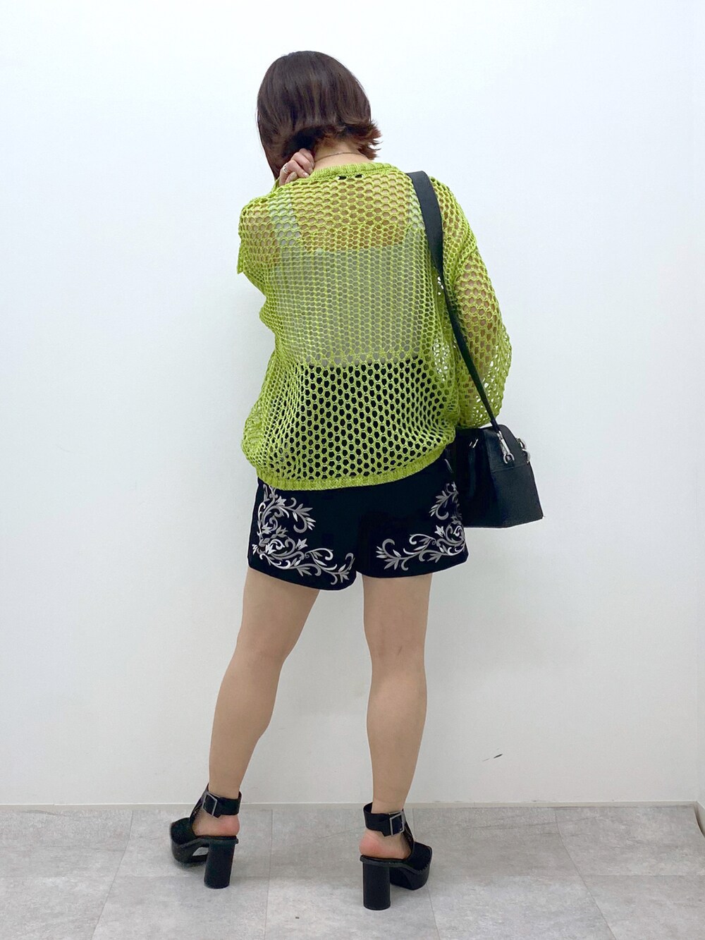ブラック系のショルダーバッグ、ブラック系のその他パンツ、グリーン系のニット/セーターを着用したレディースの春コーディネートの3枚目の写真