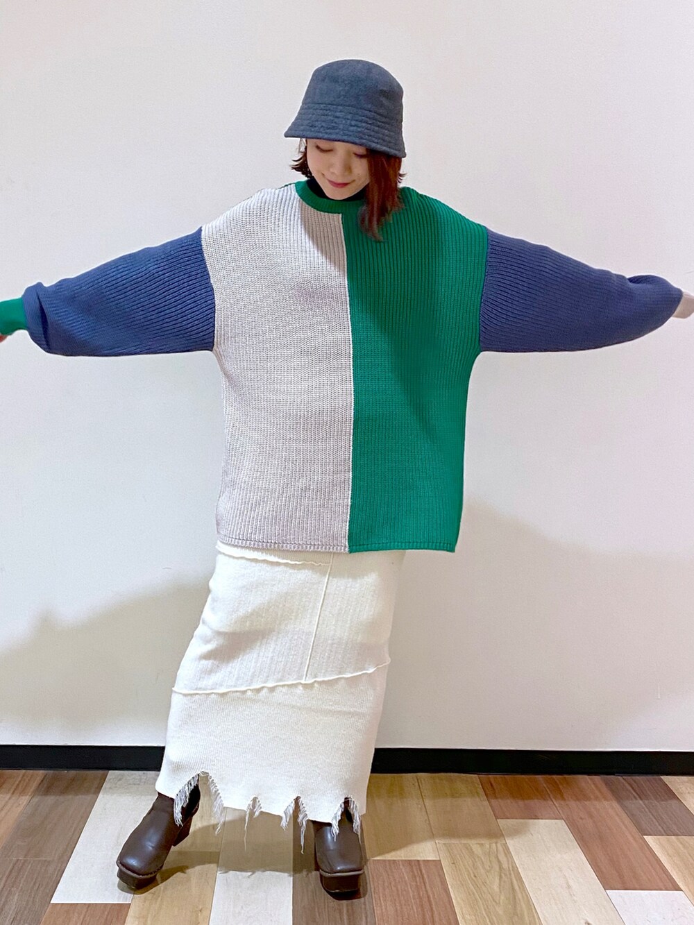 ブラウン系のブーツ、ホワイト系のスカート、グリーン系のニット/セーターを着用したレディースの冬コーディネートの3枚目の写真