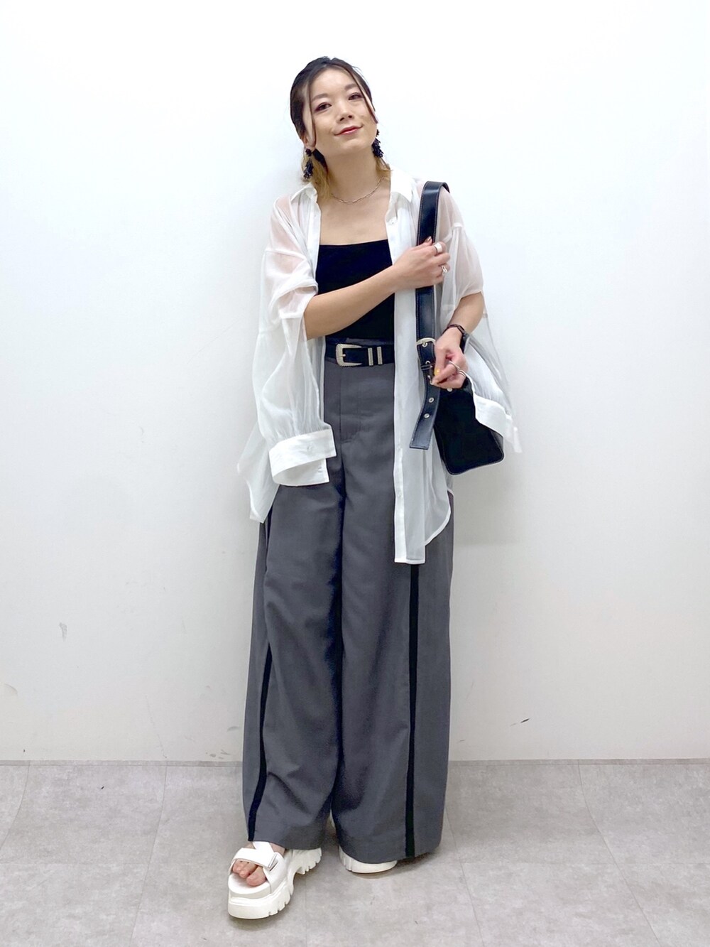 グレー系のスラックス、ブラック系のキャミソール、ブラック系のショルダーバッグを着用したレディースの夏コーディネートの8枚目の写真