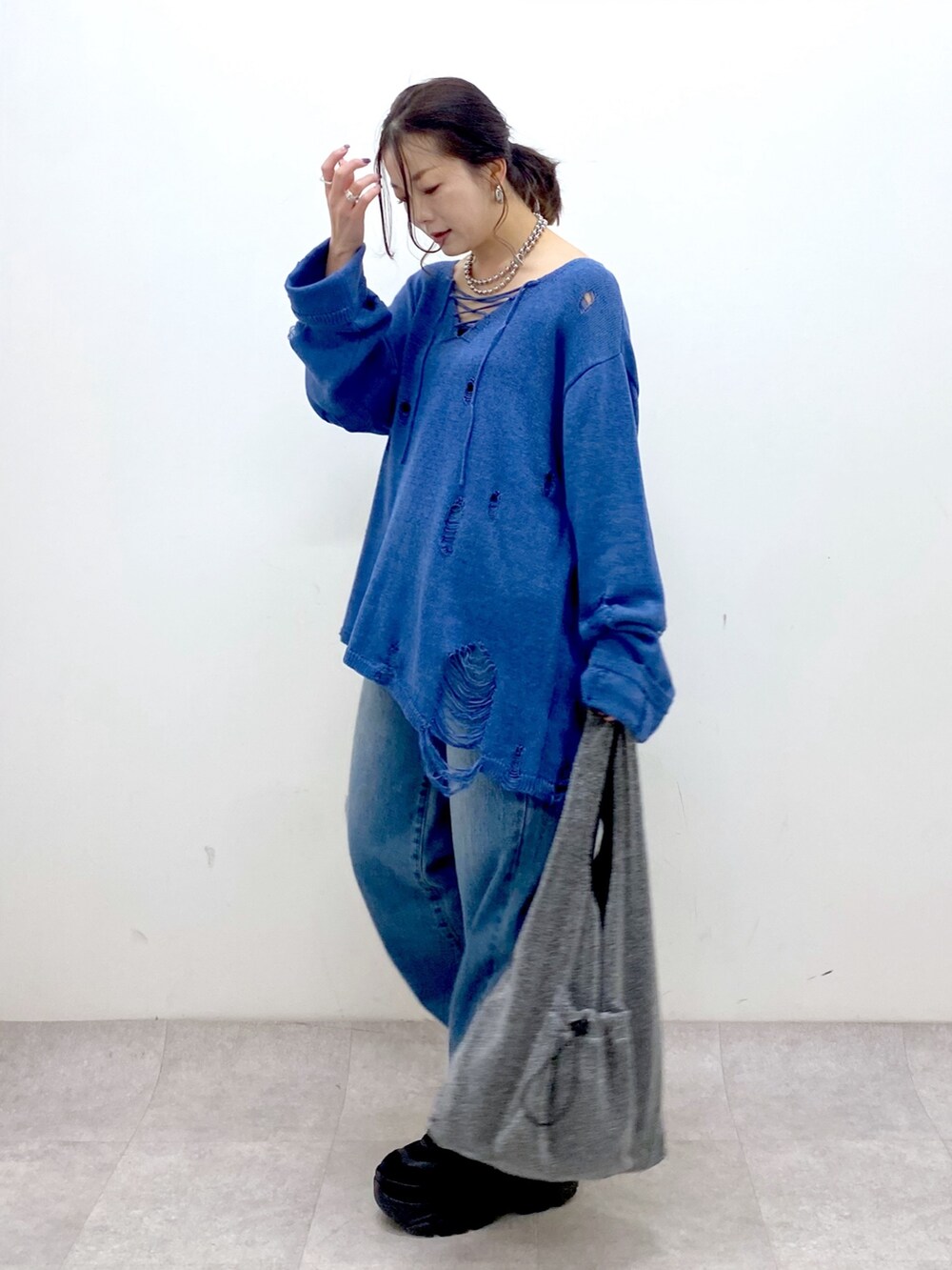 ブルー系のニット/セーター、ブルー系のデニムパンツ、ブラック系のトートバッグを着用したレディースの冬コーディネートの8枚目の写真